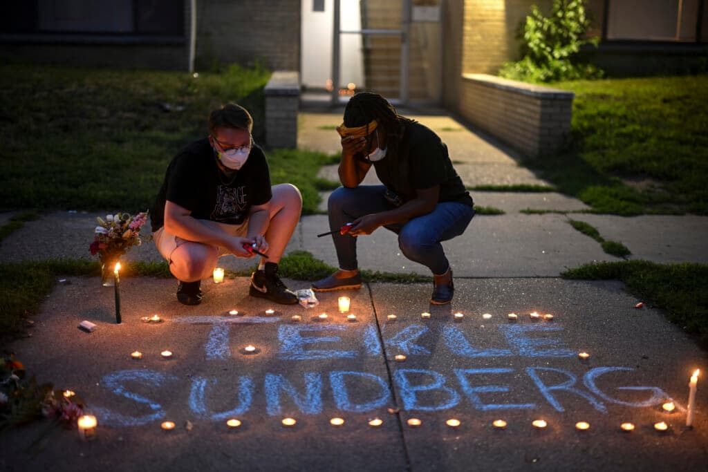Marcia Howard, activist and George Floyd Square caretaker, lights candles