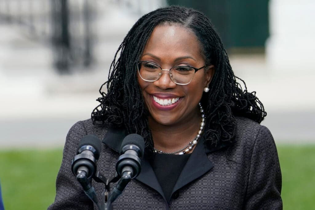 Supreme Court Ketanji Brown Jackson at a microphone wearing a black jacket