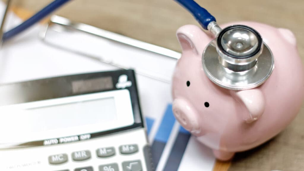 A calculator, piggy bank and stethoscope