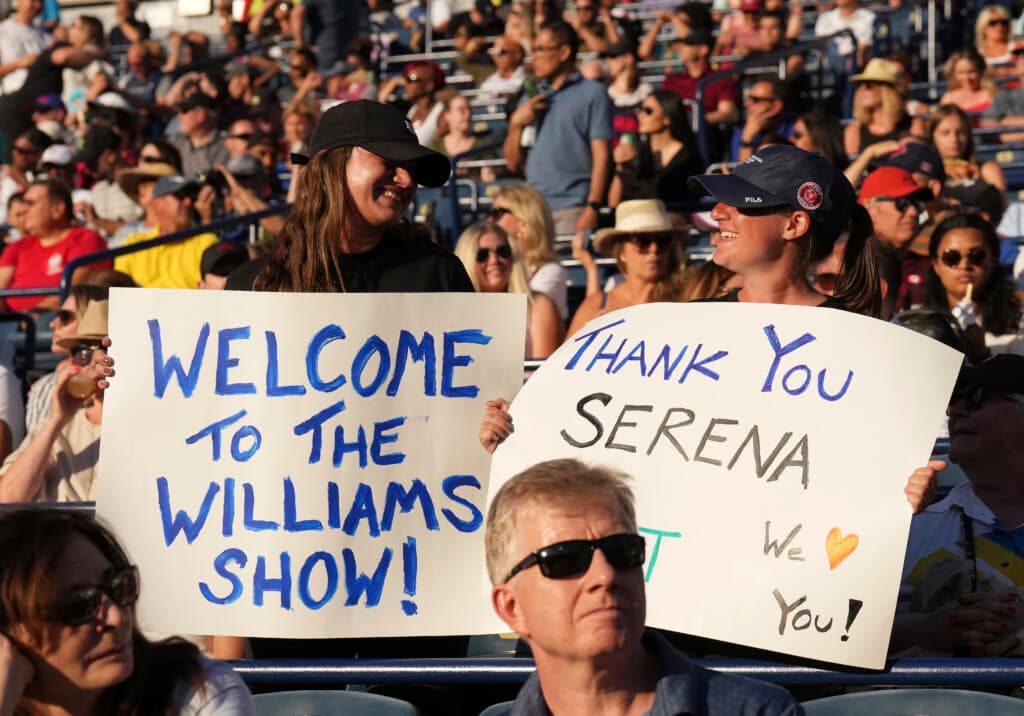Fans hold signs supporting Serena Williams