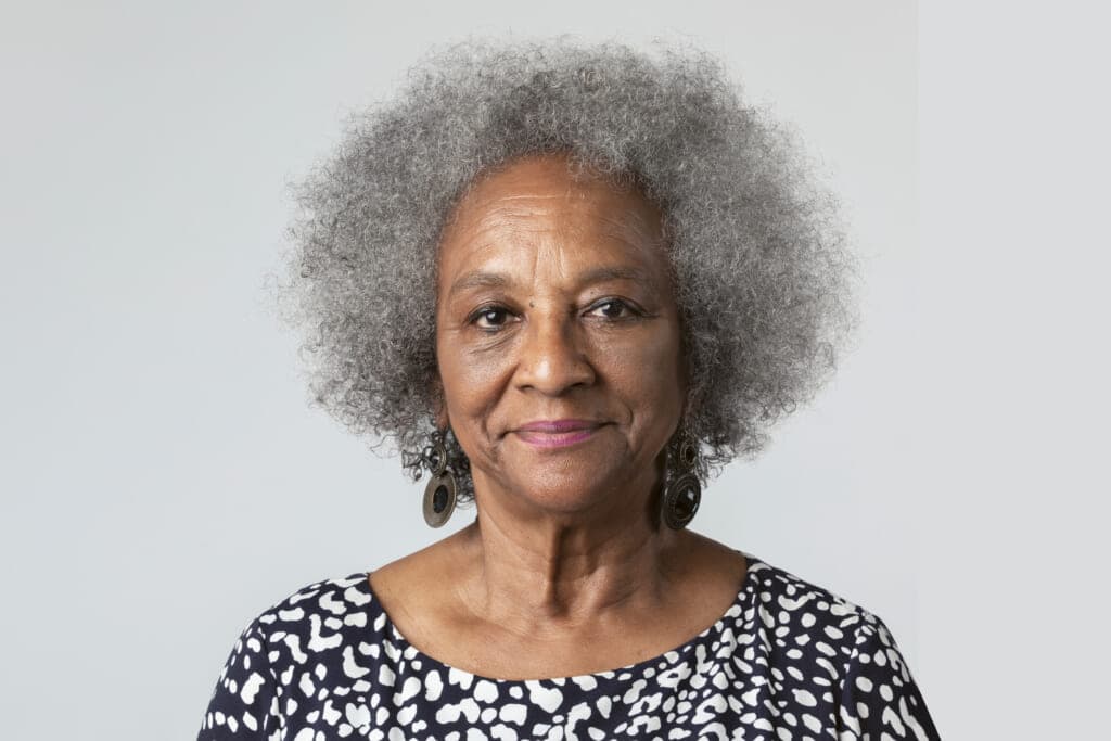 A gray-haired woman wearing a black-and-white patterned dress