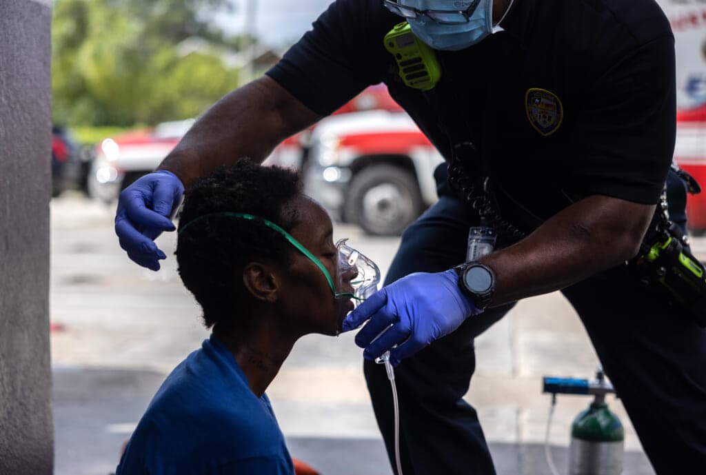 A medical worker placing an oxygen mask on a boy