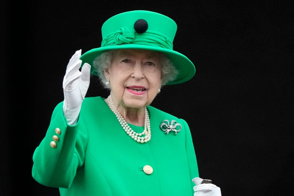 Britain's Queen Elizabeth II wearing a bright green hat and dress and white gloves