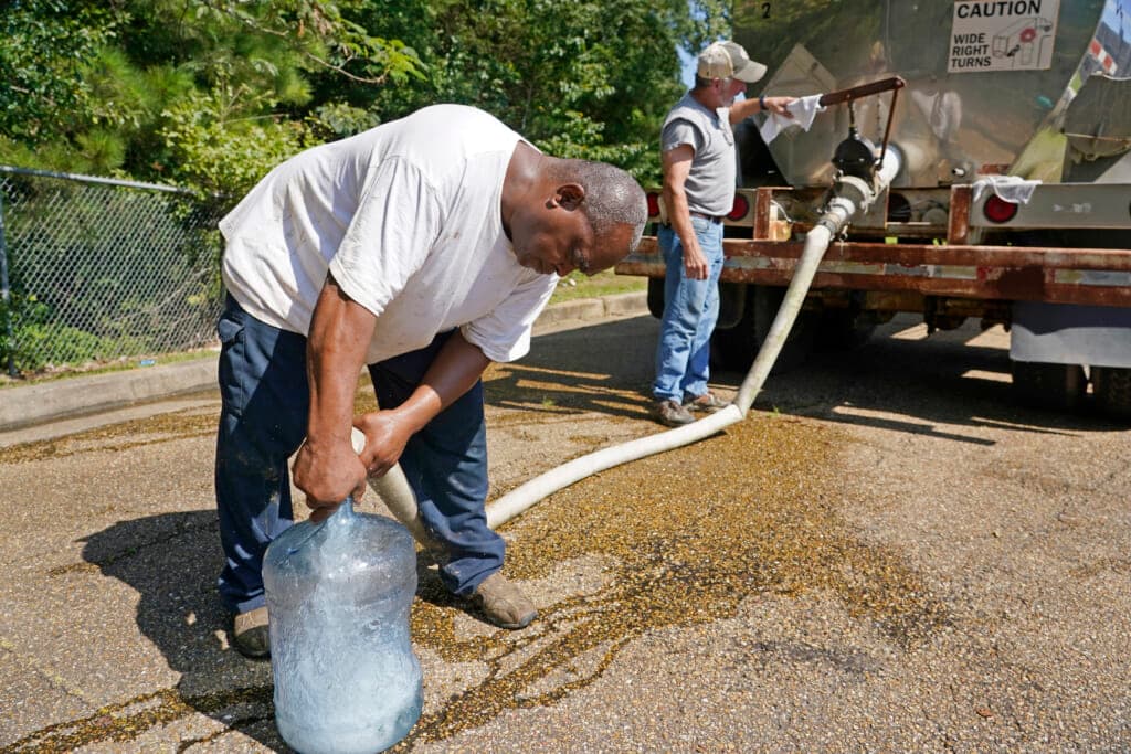 Benjamin Williams and Ty Carter fill up a five-gallon jug