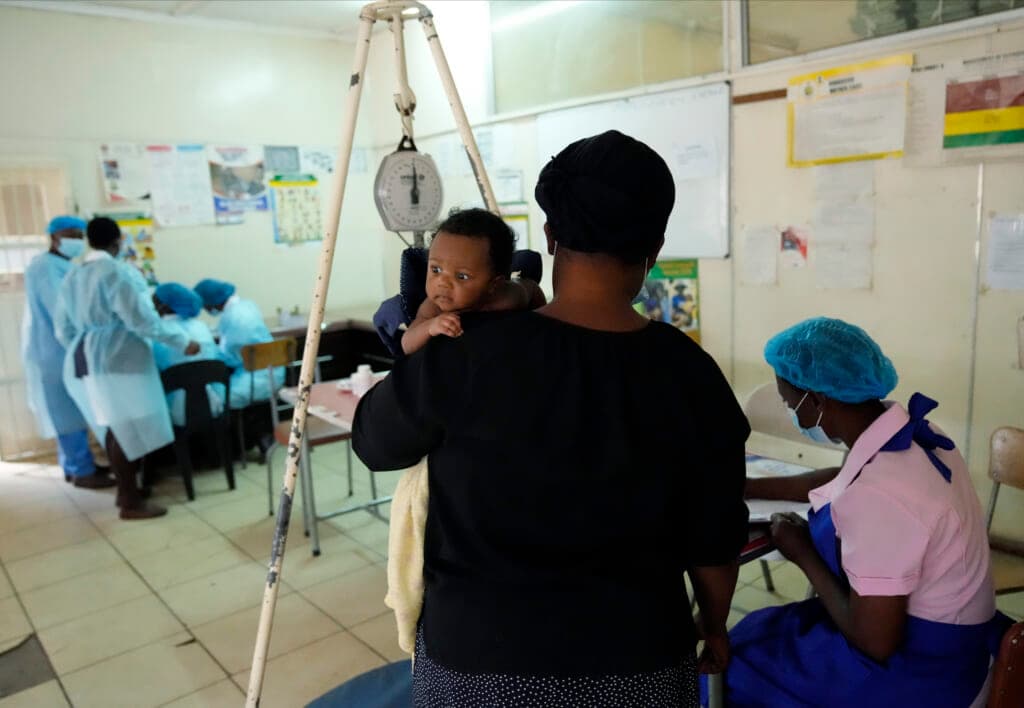 A mother waits for her baby to be vaccinated against measles at a clinic in Zimbabwe