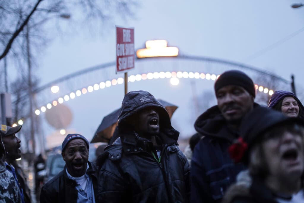 Flint residents shout while protesting outside Flint City Hall