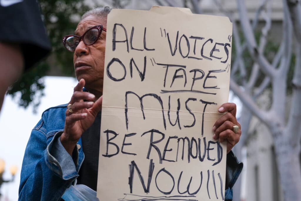 Veronica Sance holds a sign in a news conference to denounce racism and demand change
