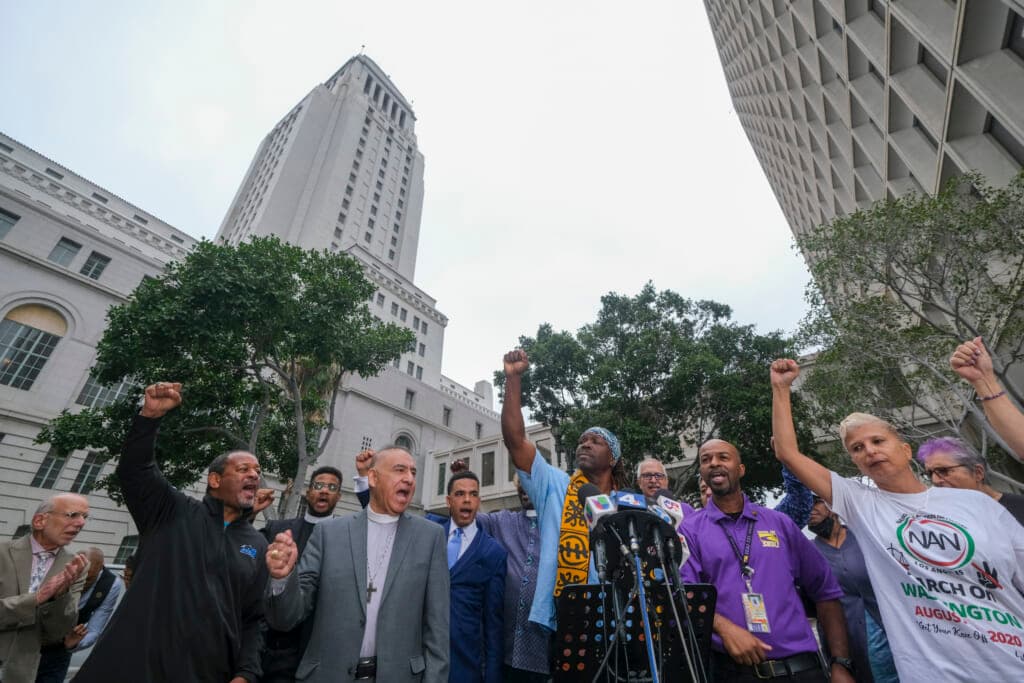 Faith, labor, immigrant and community members attend in a news conference to denounce racism
