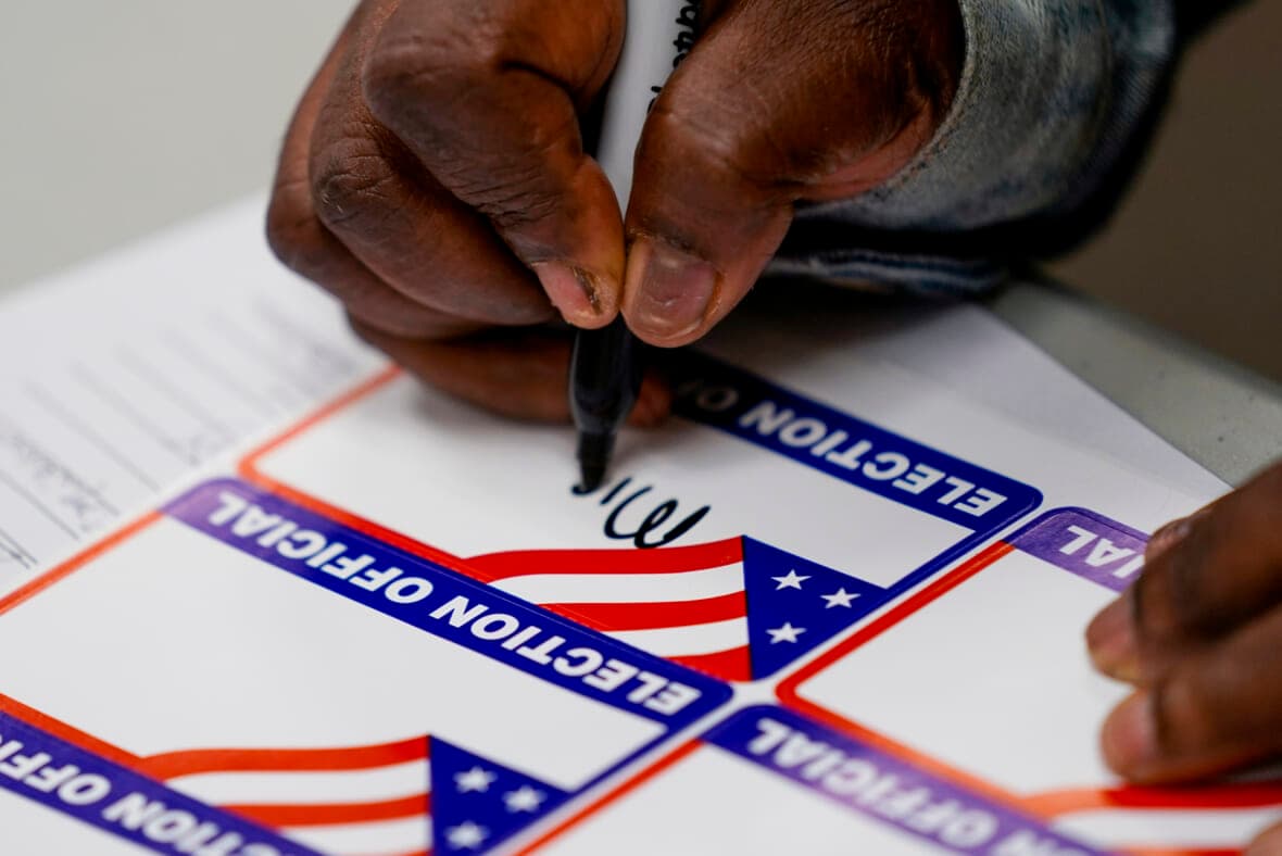 A poll worker signs in