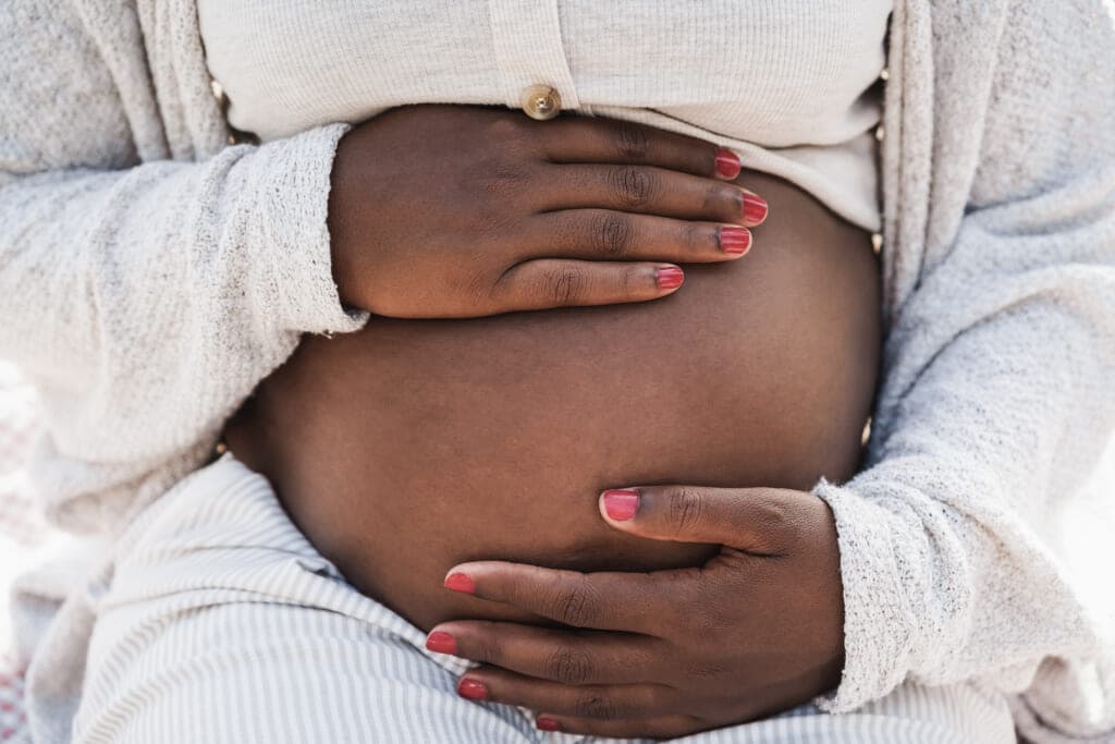 Close-up of Black pregnant woman holding her belly