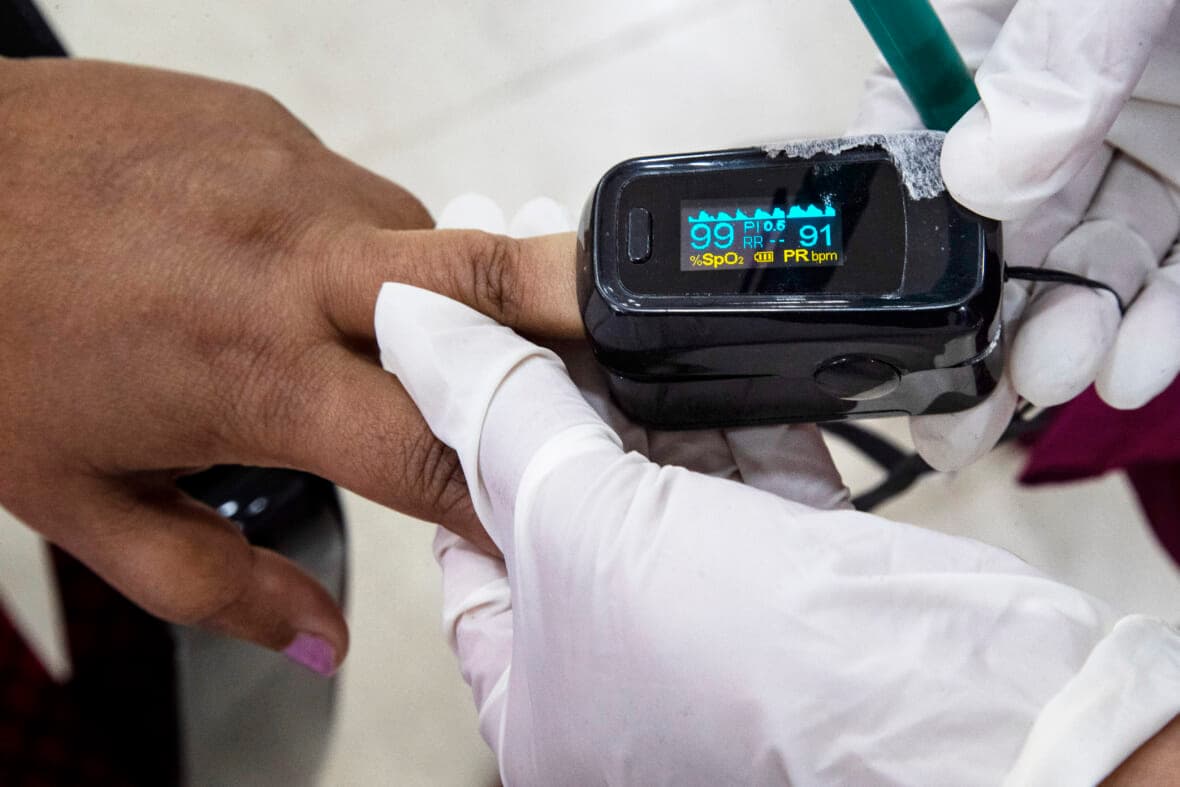 A health worker uses a pulse oximeter