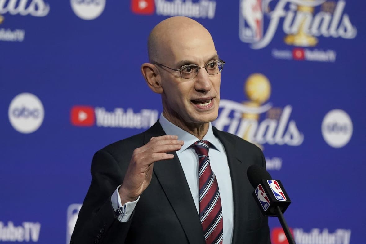 NBA Commissioner Adam Silver speaks at a news conference wearing a black jacket and red, white and black striped tie
