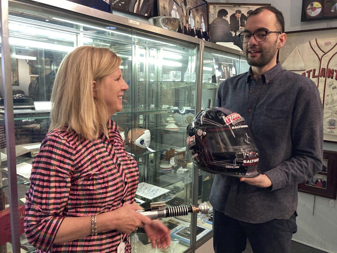 Elizabeth Haynie Wainstein and Zachary Diaz of The Potomack Company display items from the estate of Gen. Colin Powell