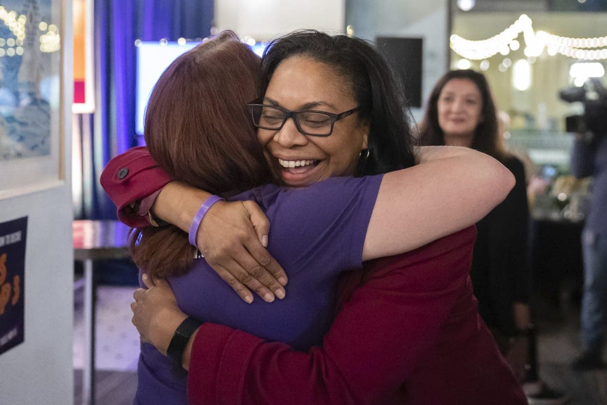 Supporters hug at a watch party for Michigan Proposal 3