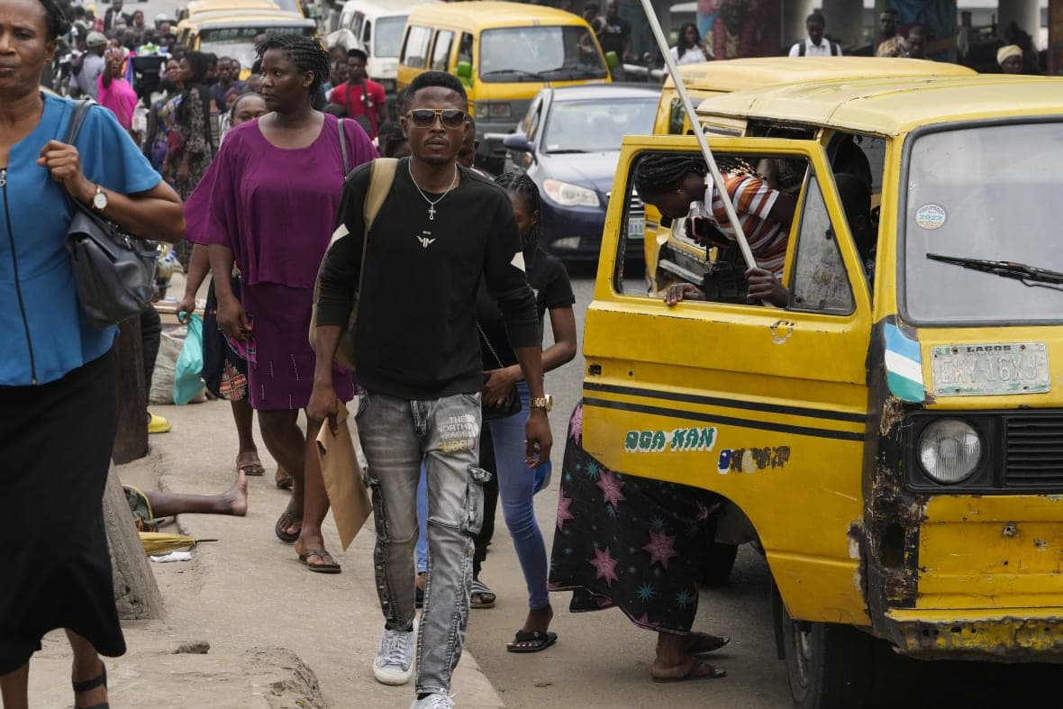 People walk on crowded streets near a yellow van