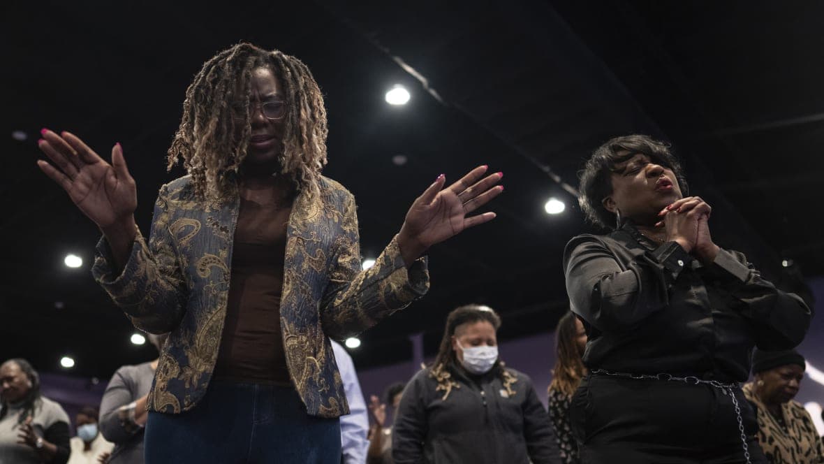 Maurene Bullock and Dr. Angela Coprew-Boyd raise their hands in prayer