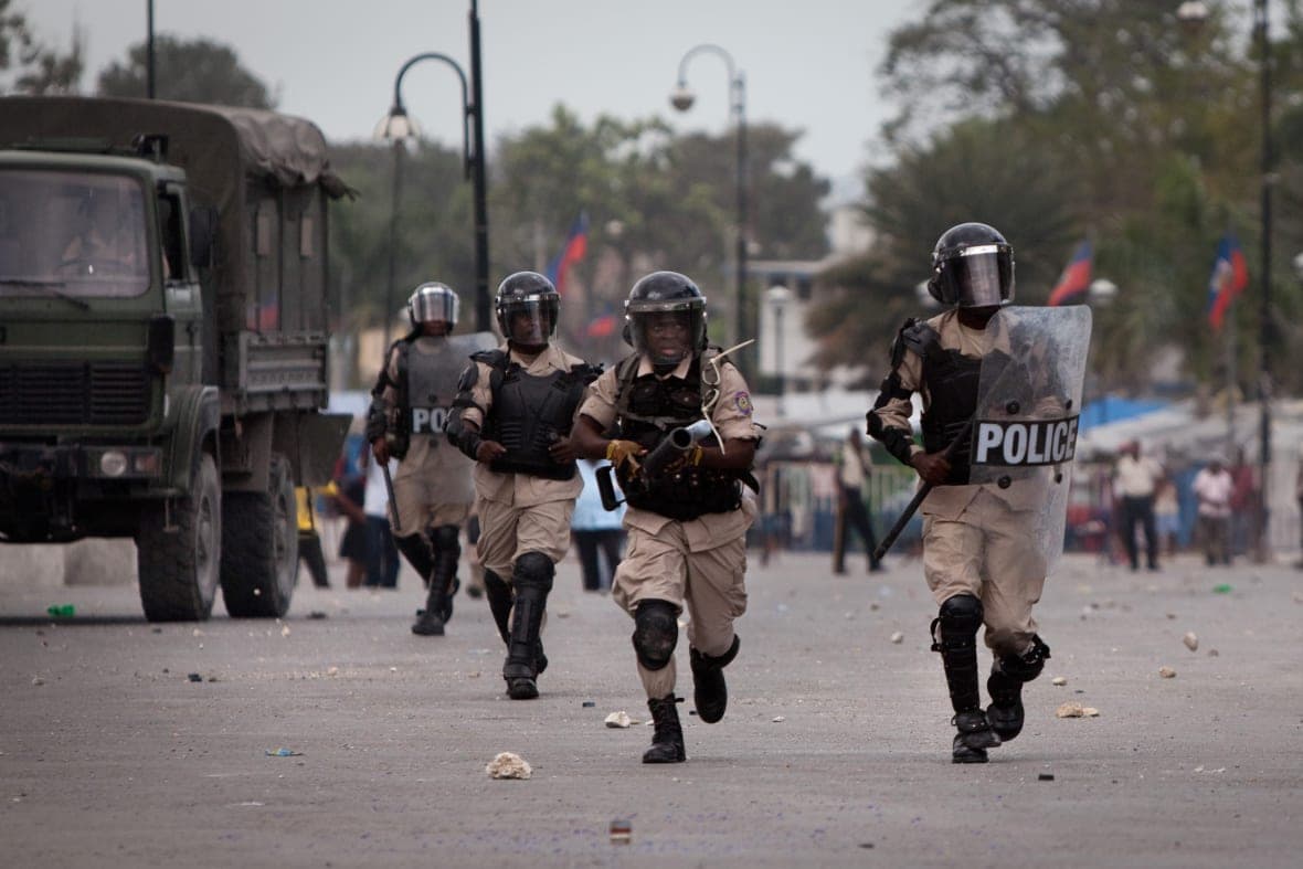 Police officers rush protestors on the street