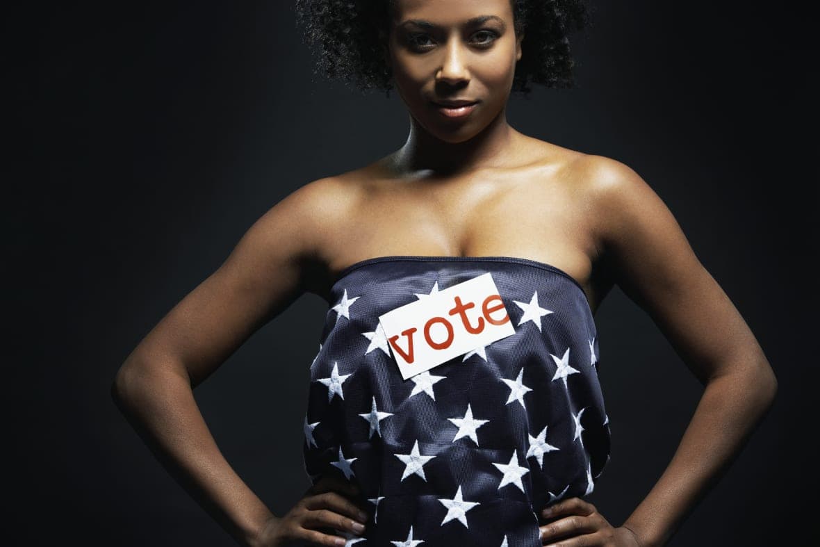 A woman wearing a strapless top labeled "Vote"