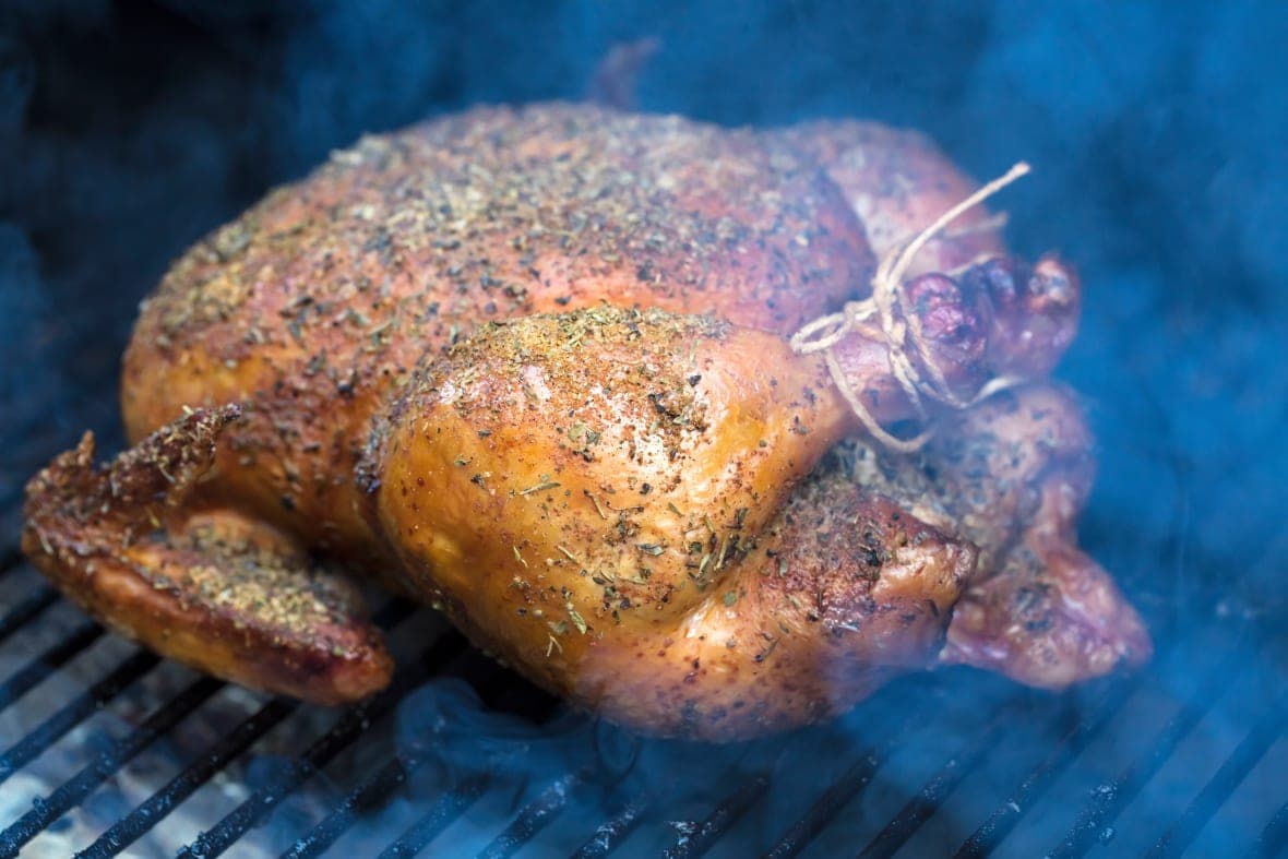 A turkey smoking on a grill