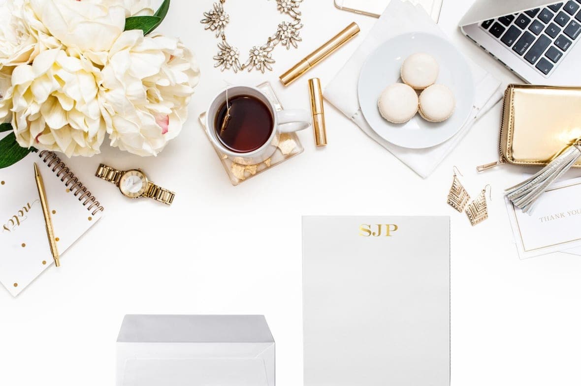 Stationery, a cup of coffee and a watch on a surface