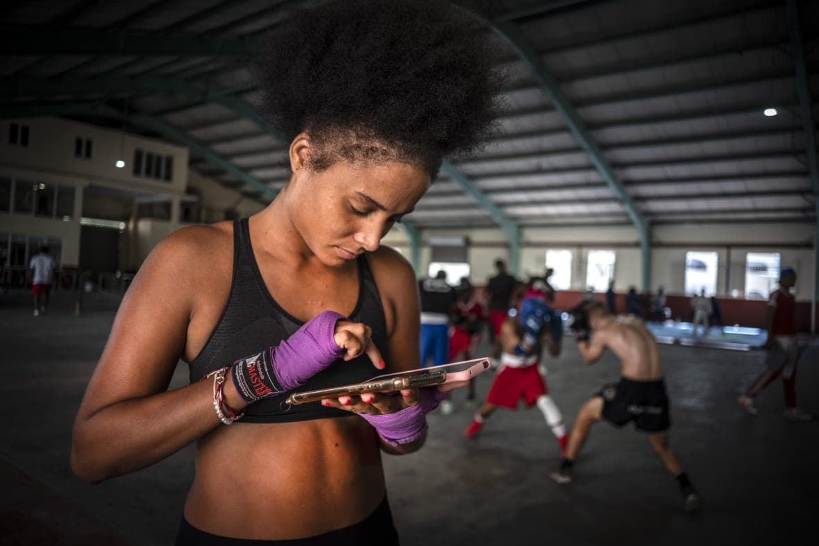 Boxer Giselle Bello Garcia texts on a mobile phone