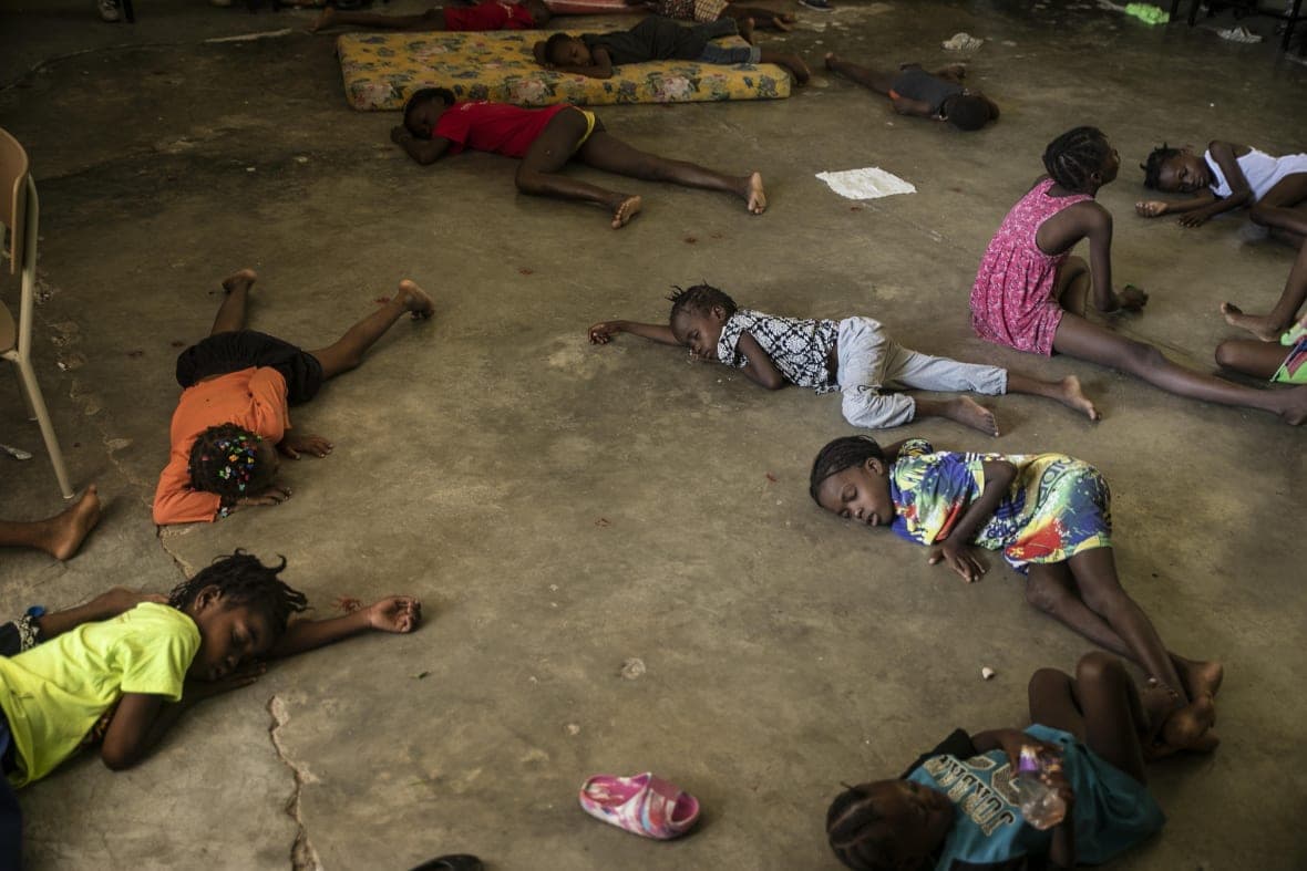 Children sleep on the floor of a school