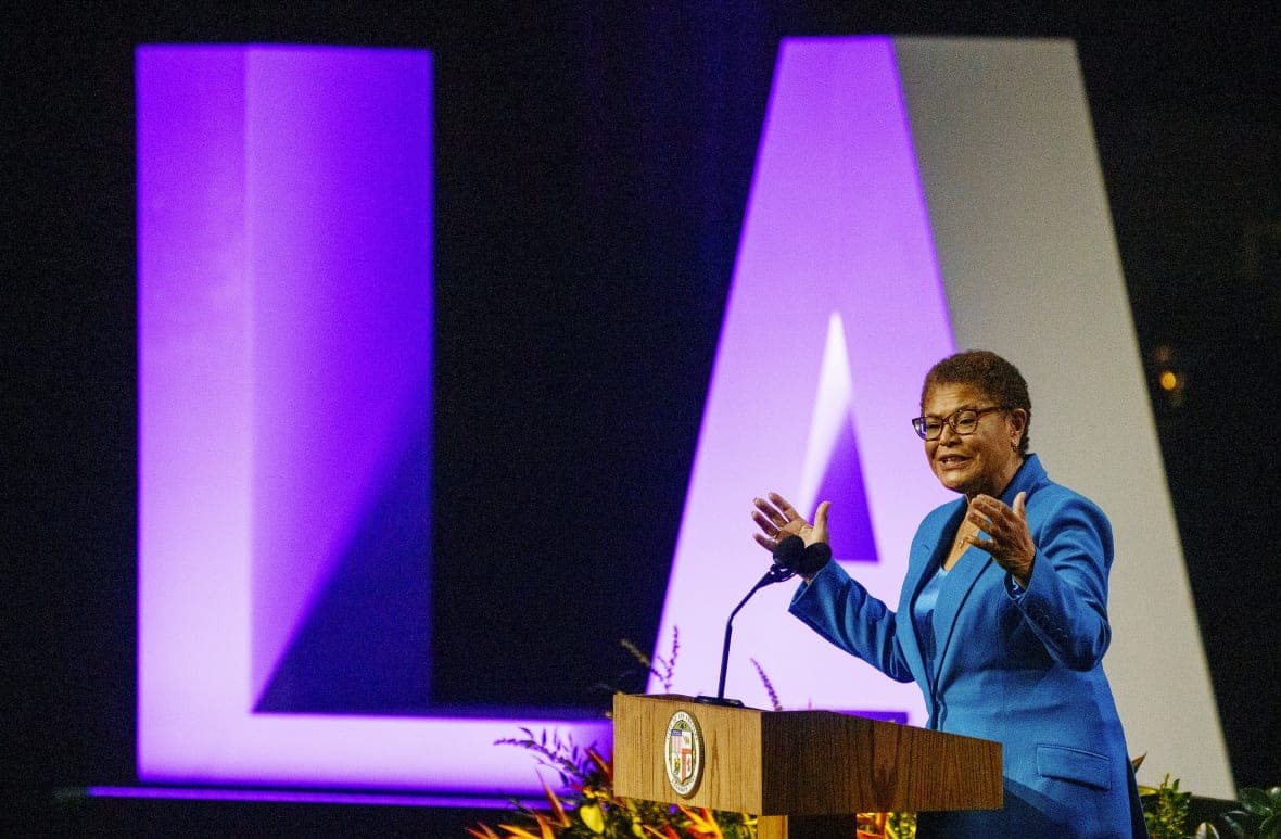 Los Angeles Mayor Karen Bass stands behind a podium wearing a blue jacket and top