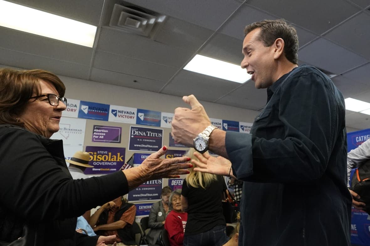 Democratic candidate for Nevada secretary of state, Cisco Aguilar, speaks to a woman