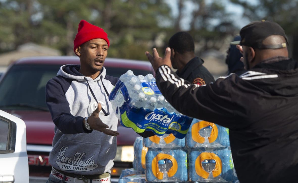 Dontavious Spann and Preston Alston toss cases of water