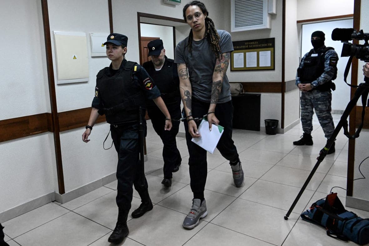 WNBA basketball player Brittney Griner in handcuffs being escorted by police 