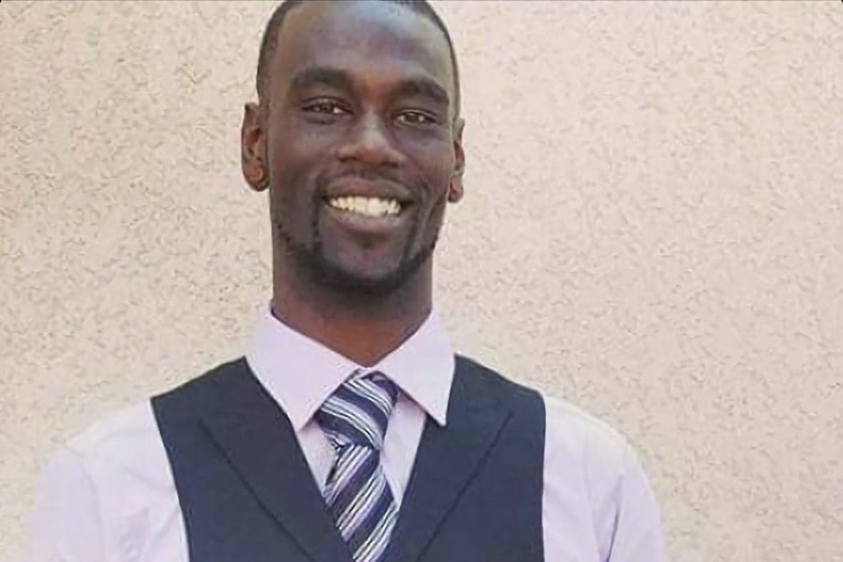Tyre Nichols, an avid photographer, wearing a white shirt, gray vest and striped tie