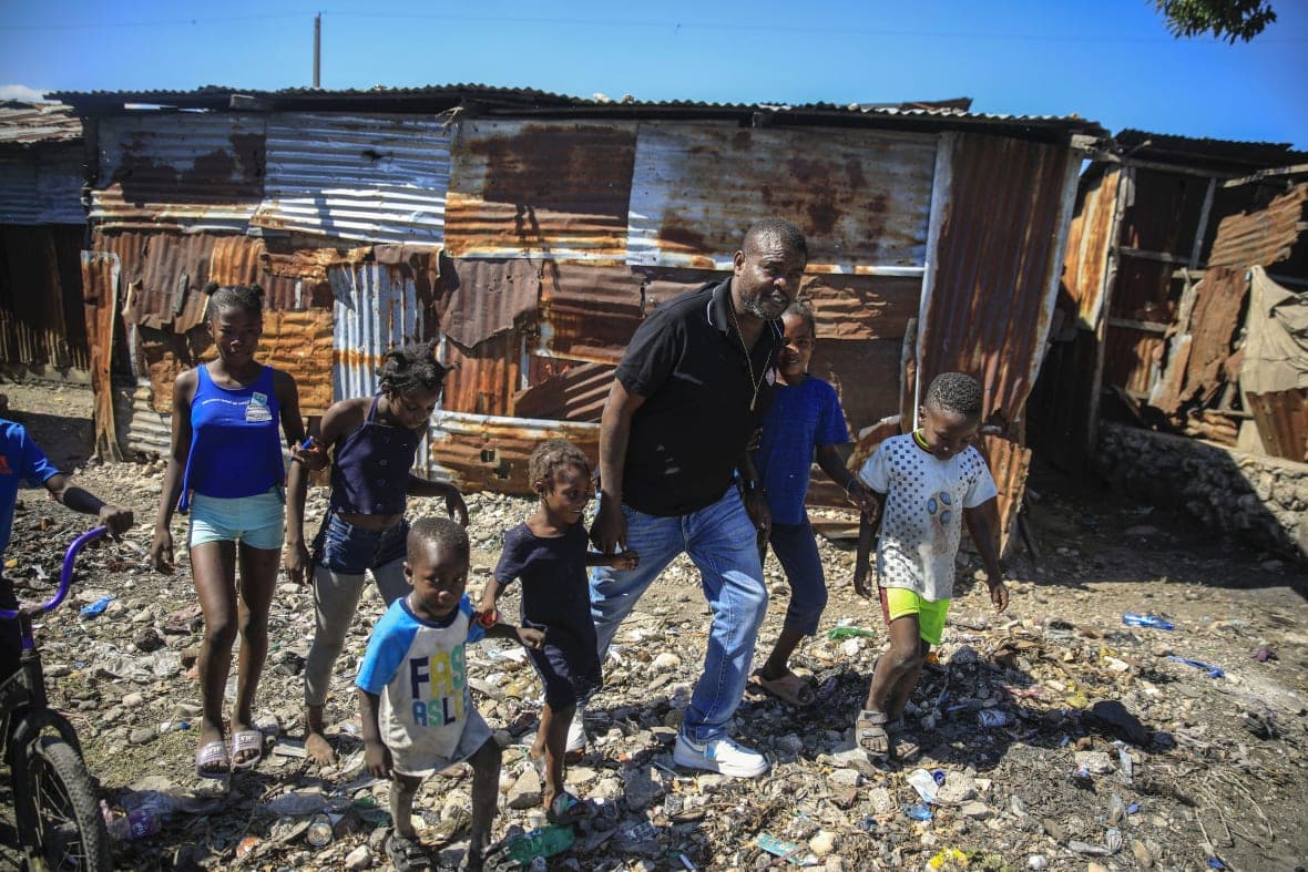 Jimmy Cherizier, the leader of the “G9 et Famille” gang, walks with children