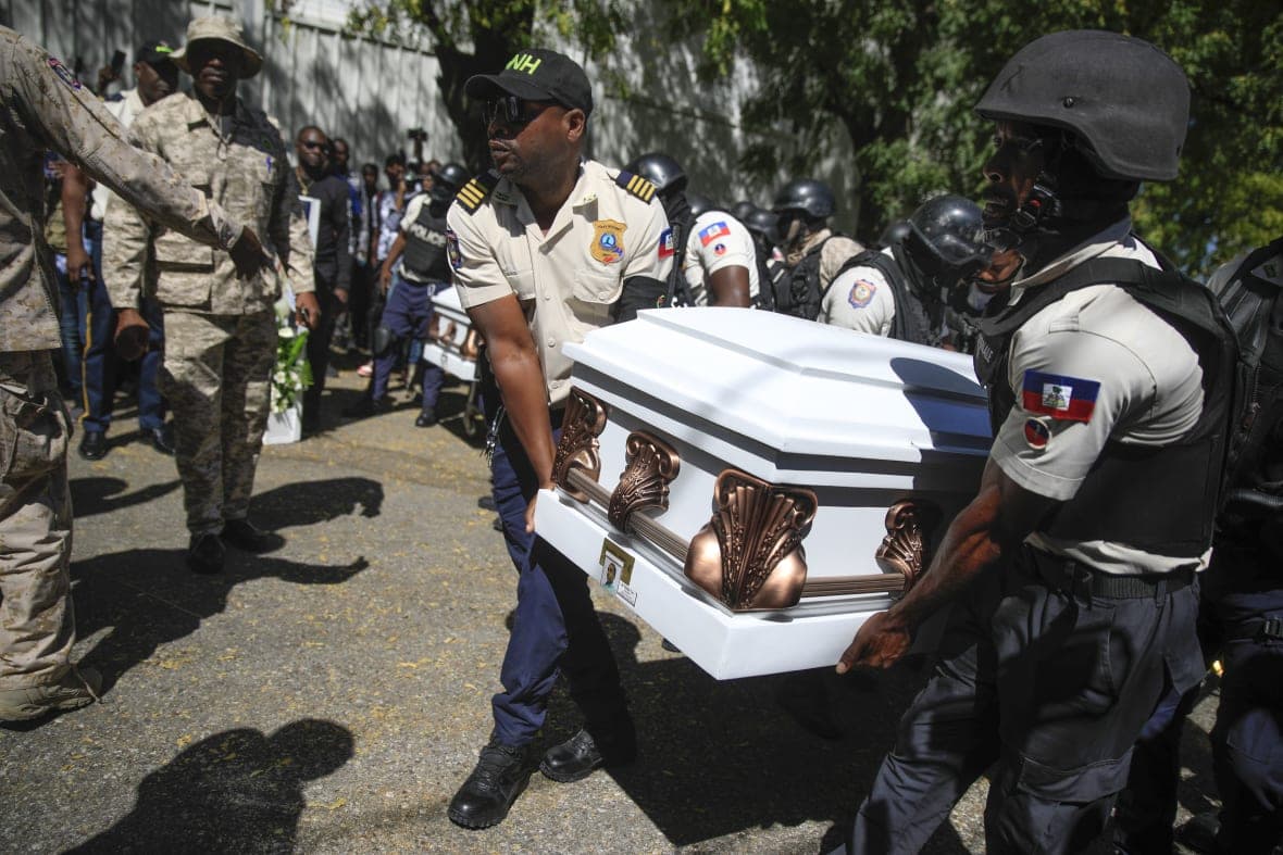 Police carry the coffin of one of three fellow officers who were killed in the line of duty