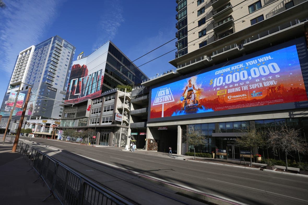 Large advertisements for NFL Super Bowl LVII adorn buildings and electronic billboards