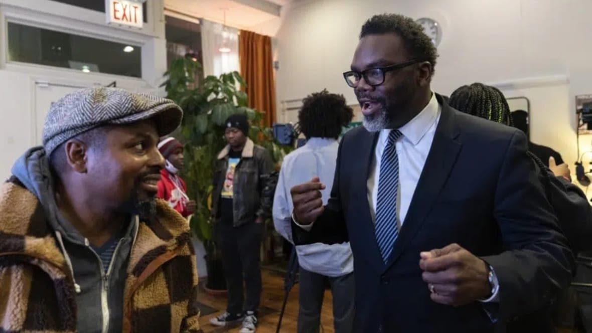 Chicago mayoral candidate Brandon Johnson (right) speaks with Bobby Price 