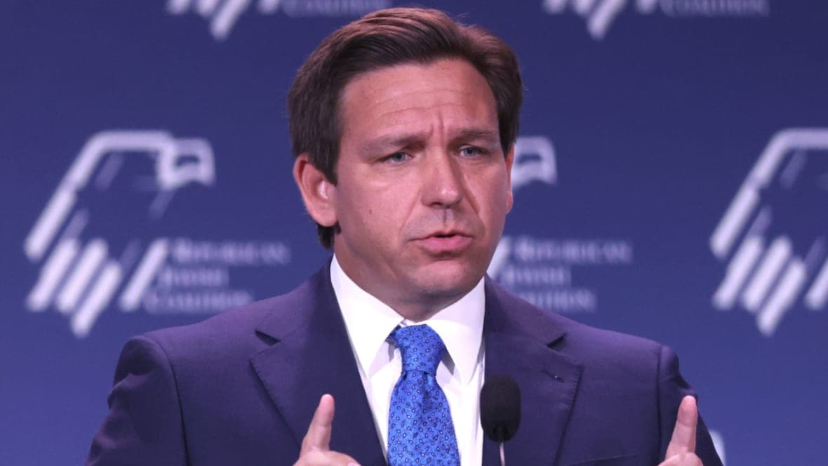 Republican Governor Ron DeSantis of Florida wearing a navy jacket and blue tie