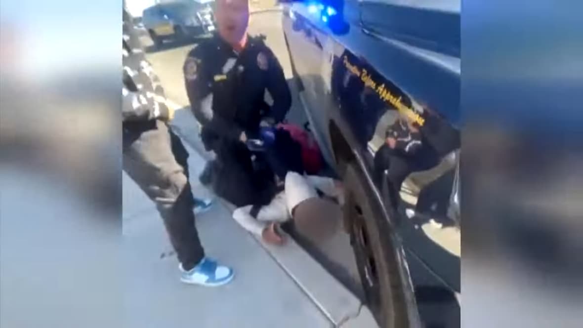 A Las Vegas police officer restrains a student