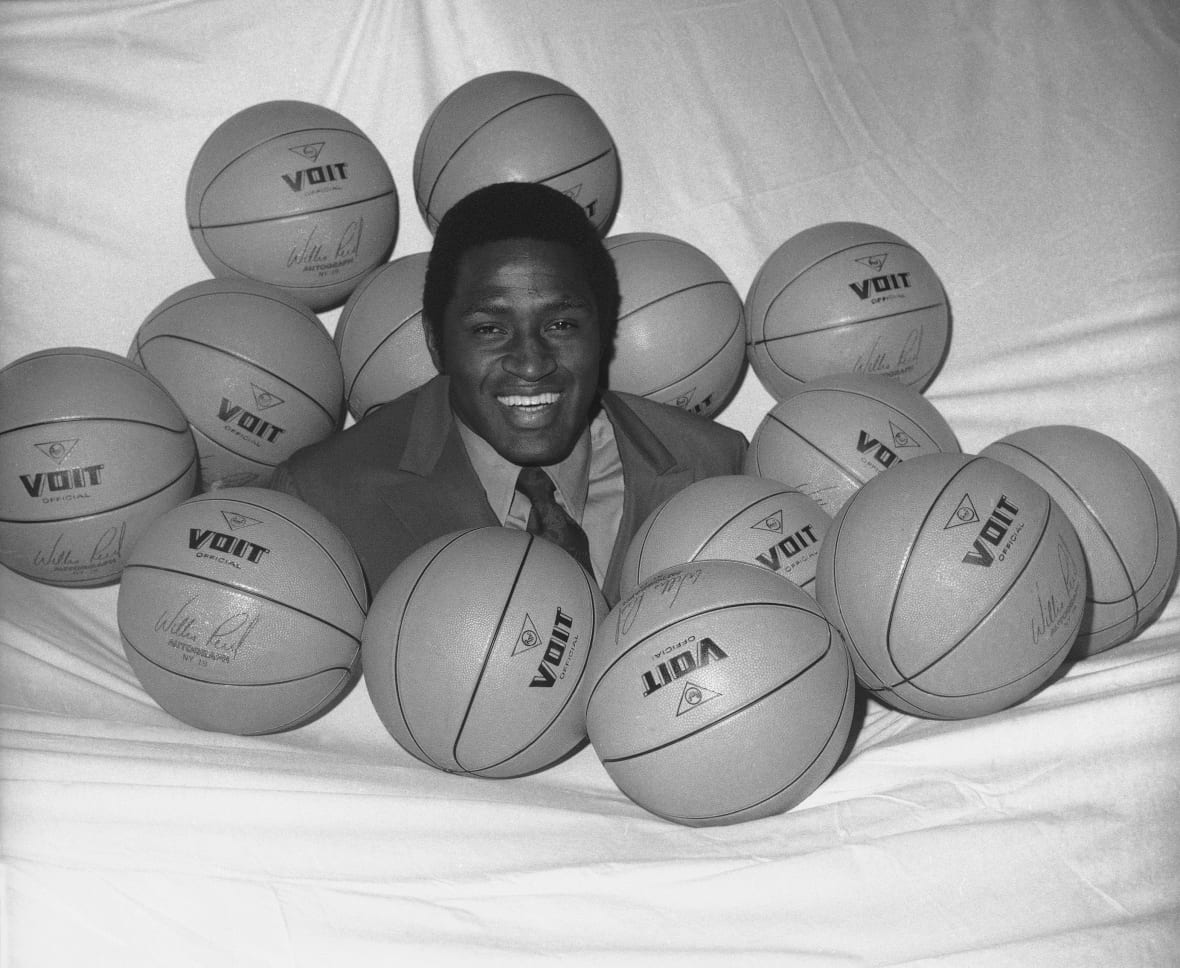 New York Knicks player Willis Reed is shown surrounded by basketballs in this black-and-white photo