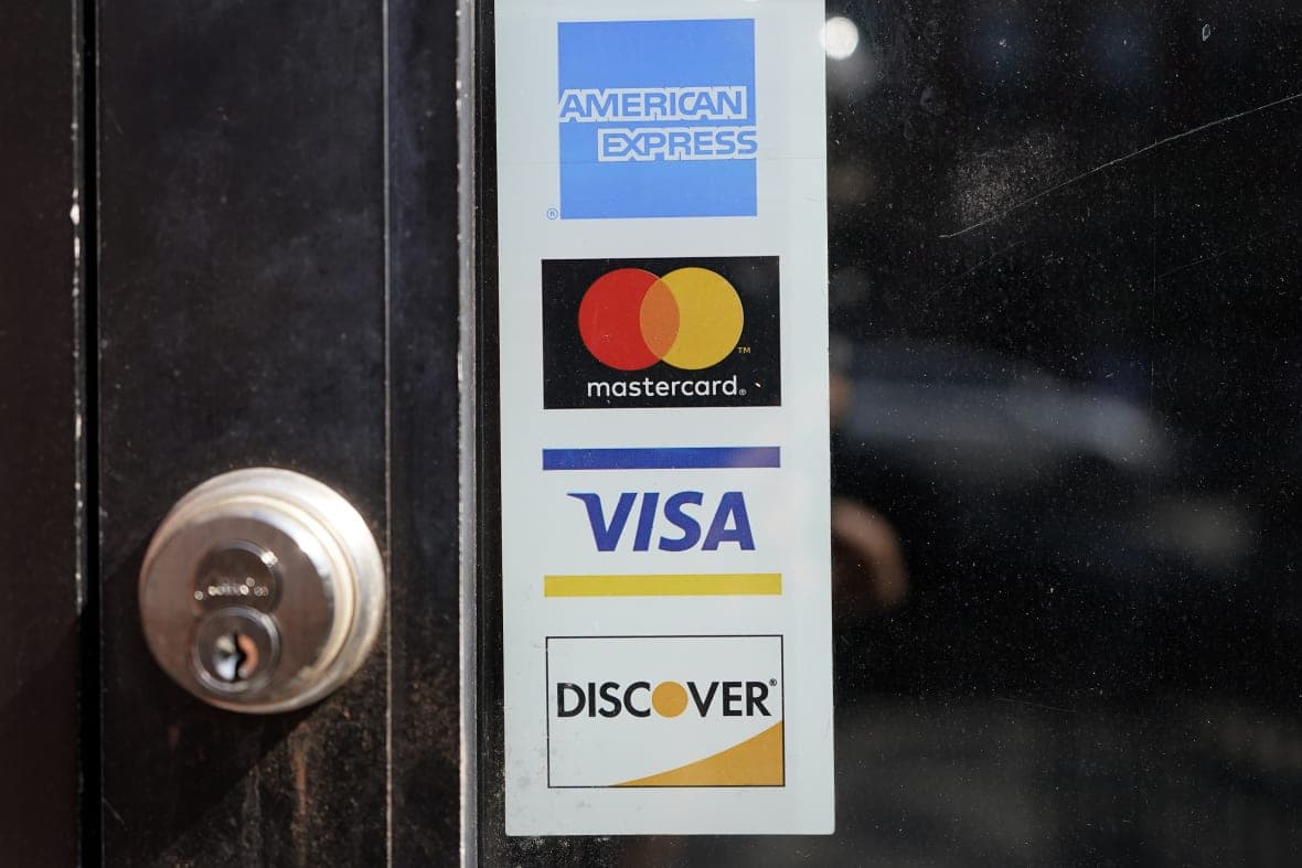 Credit card logos are displayed on a business’s door