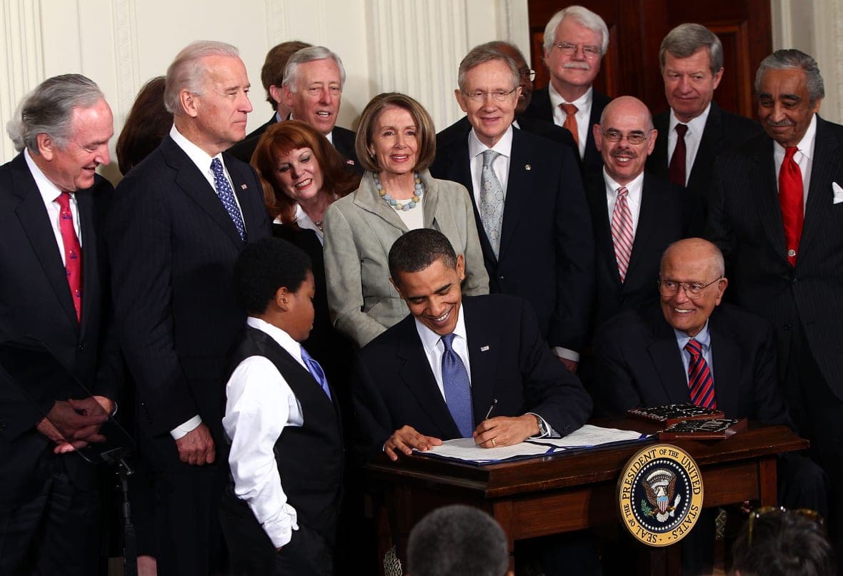 Former President Barack Obama signs the Affordable Health Care for America Act
