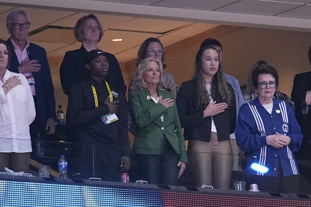 First Lady Jill Biden and others listen to the national anthem