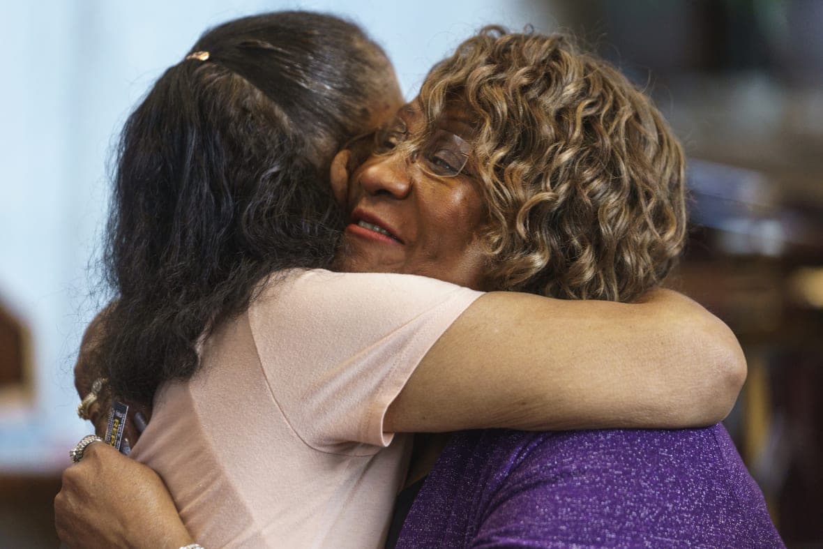 Pearl Taylor Devers, chairperson for the Palm Springs Section 14 Survivors group, is hugged