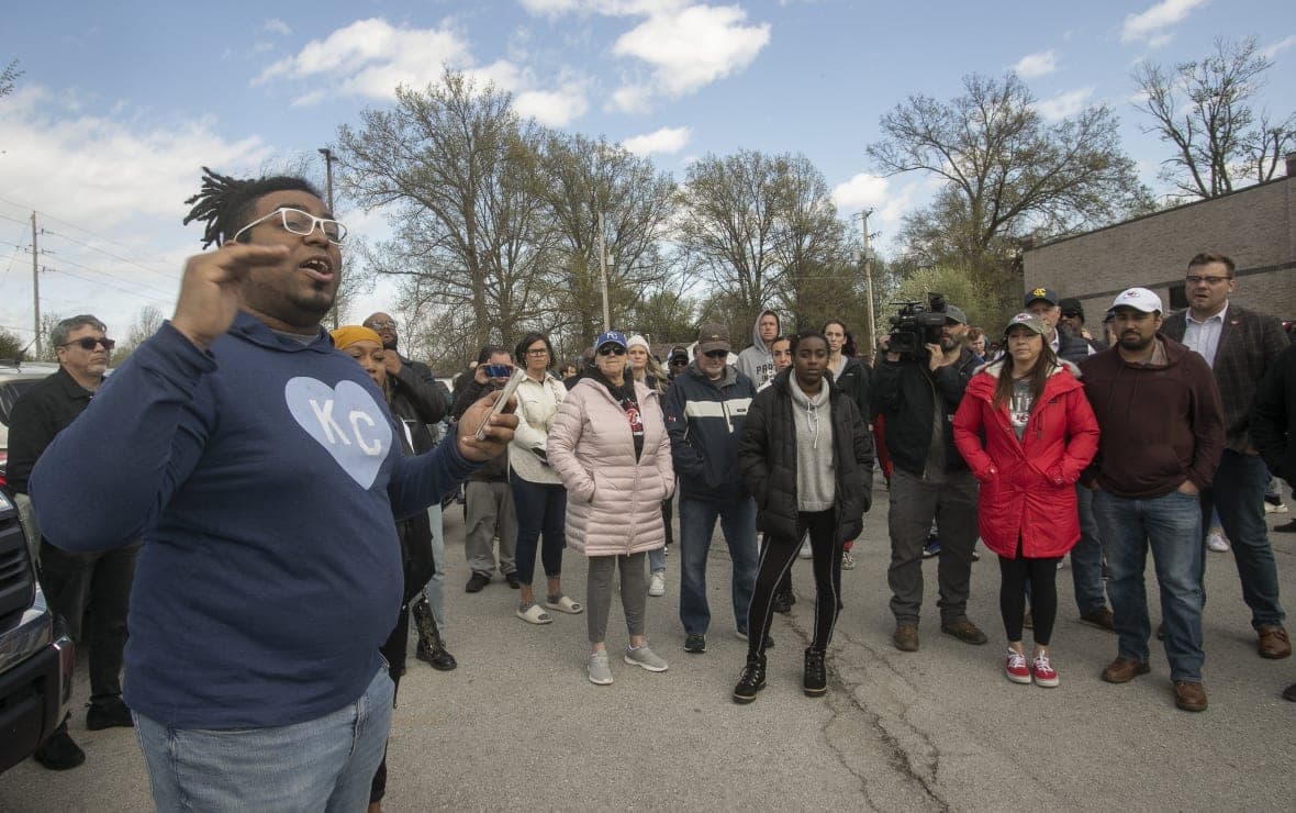 Thea Davis, pastor at Restore Community Church, left, addresses a crowd of protestors