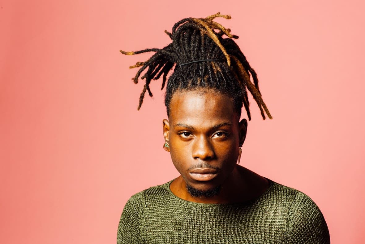 A man with hair pulled up in dreadlocks