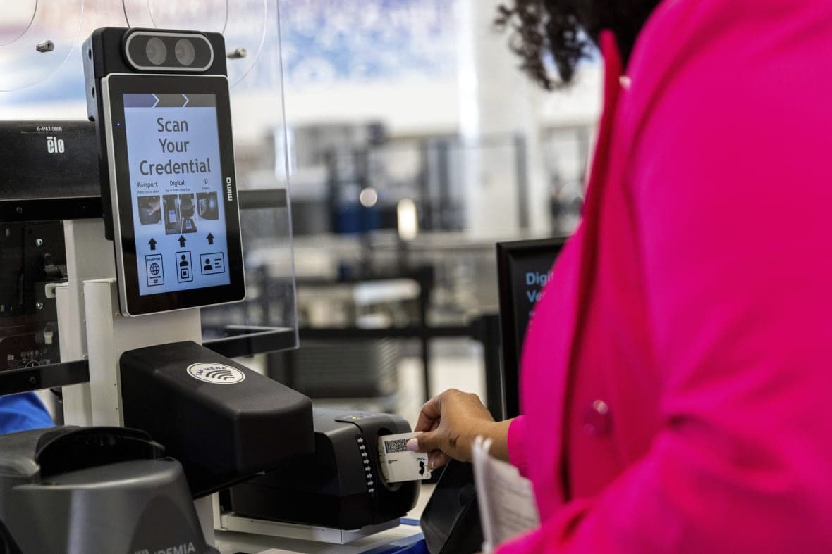 A person inserts an ID card to demonstrate the Transportation Security Administration’s facial recognition technology