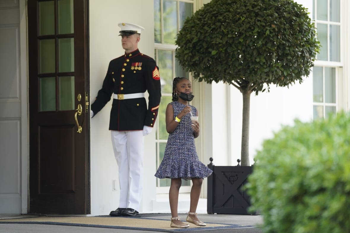 A guard holds the door as Gianna Floyd, daughter of George Floyd, walks out of the West Wing of the White House