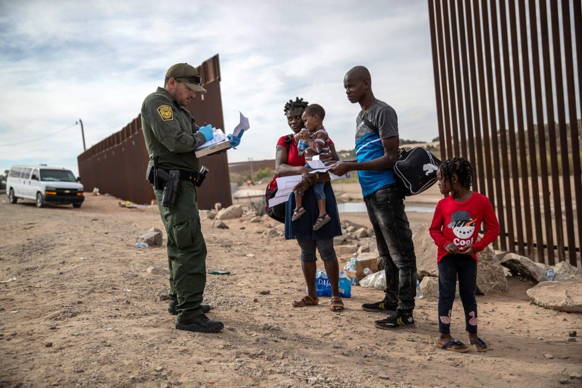 An immigrant family from Haiti is taken into custody by a U.S. Border Patrol agent