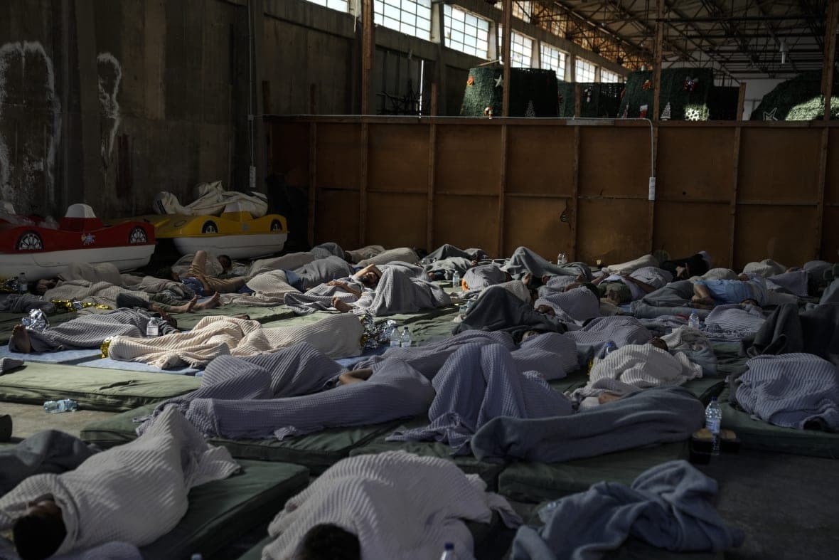 Survivors of a shipwreck sleep at a warehouse