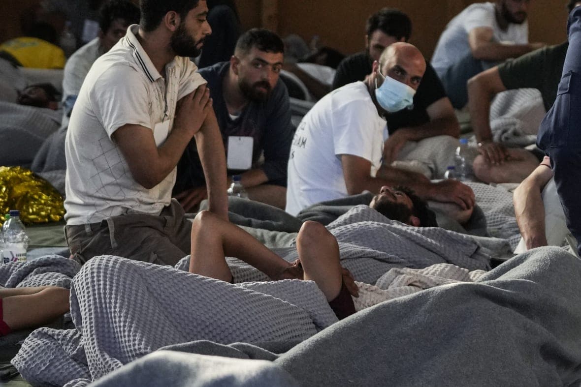 Survivors of a shipwreck rest in a warehouse