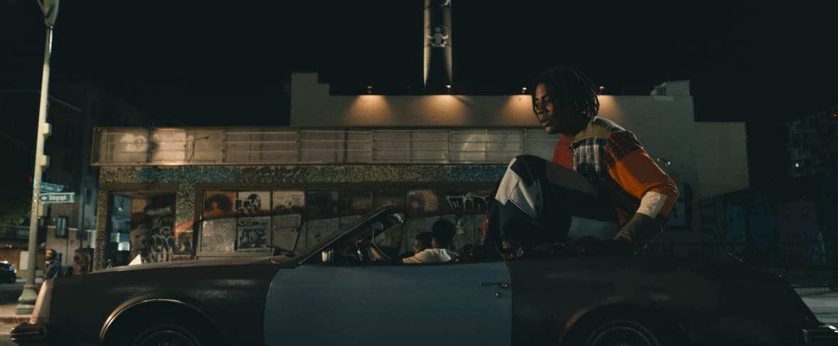 Actor Jharrel Jerome as a giant rides in the back of a car
